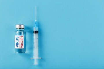 Syringes and ampoule with the vaccine against the Virus from diseases on a blue background.