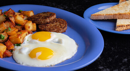 Image of a typical American breakfast. Sausage, eggs and potatos.