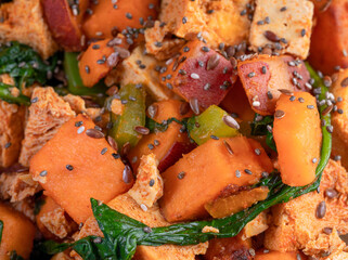 Close up image of a healthy breakfast with a tofu sweet potato scramble and fruit.