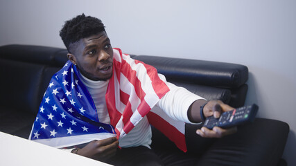 Excited african american black man with USA flag watching game on tv. High quality photo