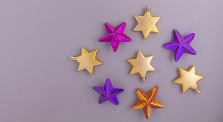 Obraz premium Colorful Christmas stars on a gray background. Banner of decorative elements