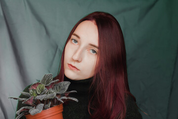 Naklejka premium Portrait of a beautiful girl with a violet. The girl has purple hair and a violet.