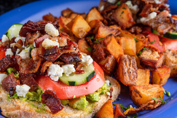 Delicious image of bacon avocado toast with cheese and potatoes. Lettuce and tomato make this dish crispy and delicious!