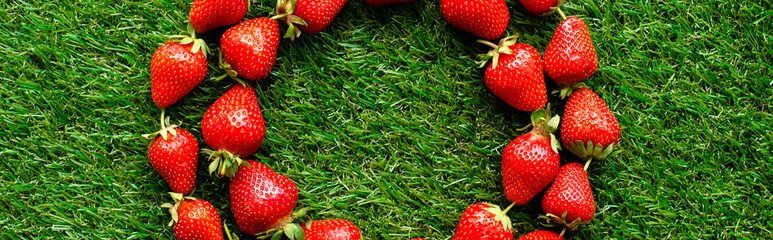 red fresh strawberries on green grass, close view