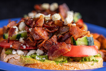 Image of a bacon, avocado, tomato and cheese sandwich.