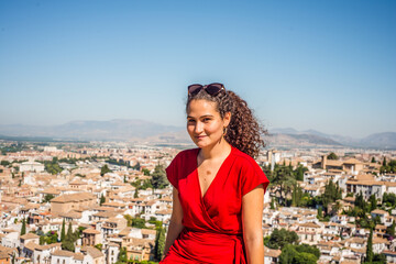 the beauty of a village in southern Spain seen from the eyes of a beautiful woman with curly hair dressed in red