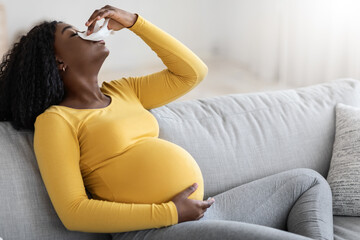 Black pregnant woman with nosebleed or bleeding from her nose