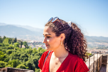 beautiful woman with curly hair and brown skin color. portrait of a red dress and a tourist in Spain.