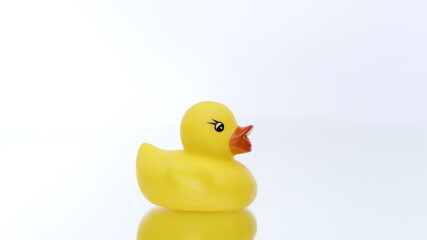 One mini yellow rubber duck rotating on isolated white background. Duck bath toy for baby shower in motion, child fun joy, kids game concept. Copy text space
