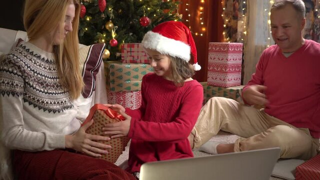 A happy couple with a child is celebrating Christmas with their friends using a video call. Family greeting your relatives on Christmas eve online. Social distancing, self isolation during quarantine