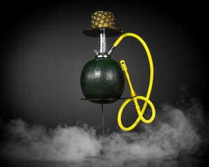 East smoking hookah. Arabian watermelon shisha. dark background with smoke