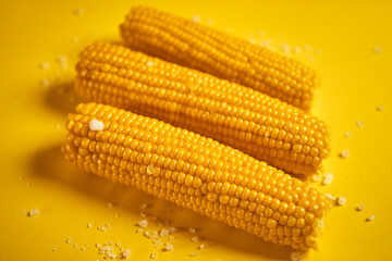 delicious boiled sweet corn on yellow background