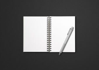 Blank open spiral notebook and pen isolated on black