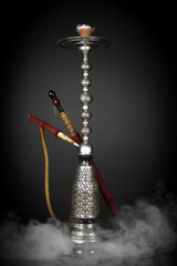 East smoking hookah. Arabian shisha. dark background with smoke