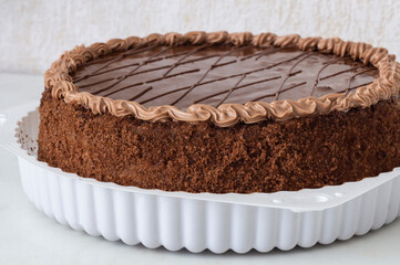 Chocolate brown cake in white box on white table