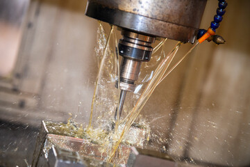 The CNC milling machine cutting the  mold parts with oil coolant method. The mold and die...