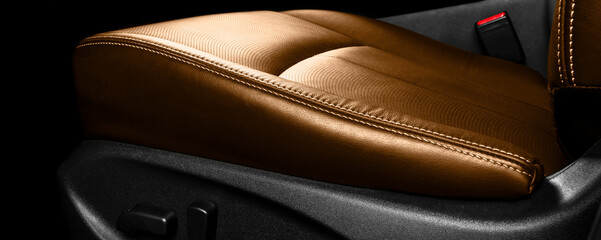 Brown leather interior of the luxury modern car. Perforated orange leather comfortable seats with stitching. Modern car interior details. Car detailing. Car inside