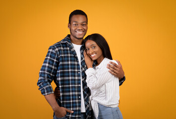 Naklejka premium Portrait of happy young african american man and woman in casual hugging and looking at camera