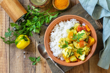 Indian cuisine dish sabji. Traditional Indian vegetable stew with soft cheese and turmeric on a wooden table. Top view flat lay background.