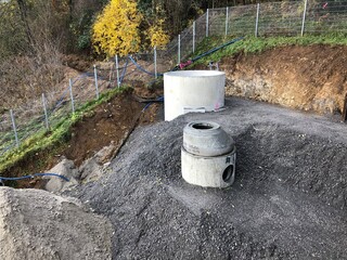 Aufbau von einem Abwasserschacht auf einer geschotterten Fläche