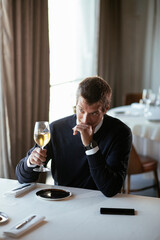 Handsome businessman drinking wine. Businessman enjoying in the restaurant