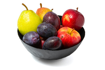 Covered with drops of water fresh ripe plums, apples and pears in a black bowl isolated on the white background.