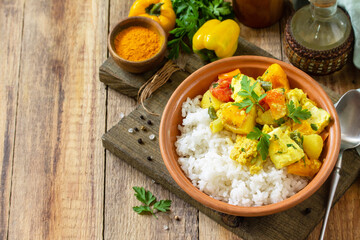 Indian cuisine dish sabji. Traditional Indian vegetable stew with soft cheese, turmeric and rice on a wooden table. Copy space.