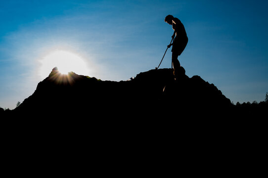 Climber on sunset sky background