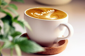 Latte art coffee on working table in the office. Cappucchino with white bright background.