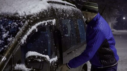 man gets out of the car in winter,happy man arrived at night by car in winter