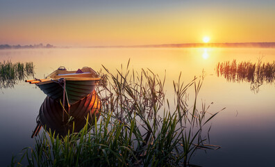 Boat on the lake in the rays of the rising sun and fog, zemborzycki lake © RafalDlugosz