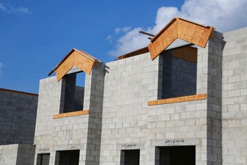 Two windows with wood frames in townhomes under construction in a hot sunny afternoon