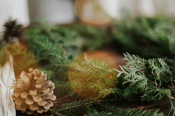 Christmas tree green branches, pine cones and festive lights on rustic background. Merry Christmas