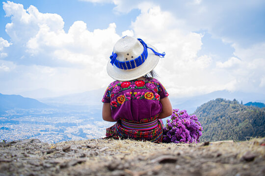 ni&ntilde;a usando sombrero con su indumentaria color morado 
