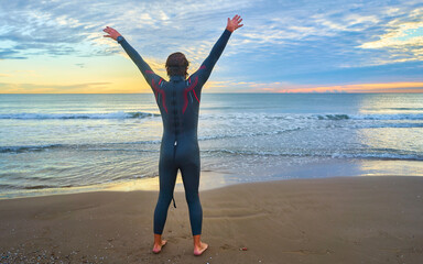 Triathlete man preparing to swim in the sea at sunrise