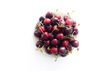 bowl with red raw fresh cherries on white background, close view 