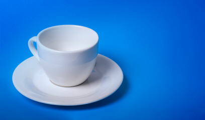 illuminated empty white Cup on a blue background with a copy of the space
