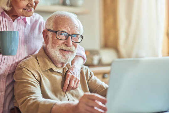 Smiling senior woman hugging her husband during the breakfast