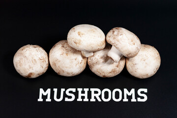 A bunch of white champignons. The label at the bottom is MUSHROOMS.