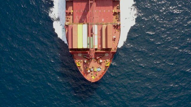 Luftaufnahme eines mit Container Frachters in Fahrt &uuml;ber blauem Ozean