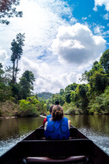 Fototapeta na wymiar young woman sitting in boat on river in jungle