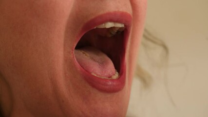 Taking a saliva sample from a female's mouth with cotton swab. Close up.