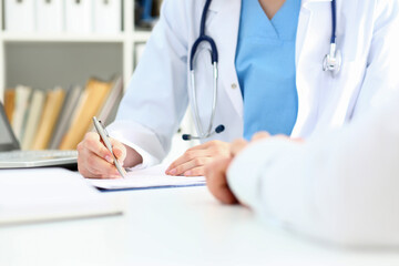 Female doctor hand hold silver pen filling patient list at clipboard pad closeup. Physical, exam, er, disease prevention, ward round, visit check, 911, prescribe remedy, healthy lifestyle concept