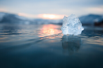 Ice on the frozen lake at sunset. Macro image, shallow depth of field. Winter nature background
