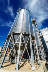 Tanks and agricultural silos of grain elevator storage. Loading facility building exterior. View from below.