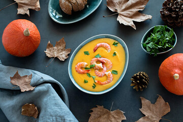 Bowl with pumpkin and shrimp cream soup, autumn food concept, top view.