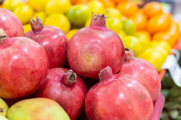 A lot of red pomegranates in the street market for sale. Juicy and tasty pomegranate fruits