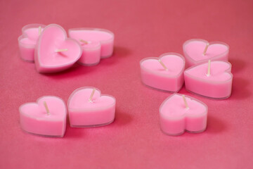 Pink candles in the shape of a heart for the holiday. Pink satin.