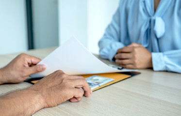 businessman hand holding bribe money to government officials sign contracts for business projects, put money under contract files, ideas of corruption and anti-bribery