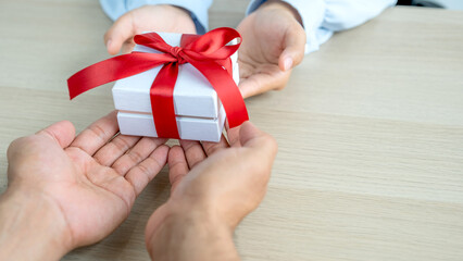 Gift box in hands, Men's hands are giving gifts to women's hands at the festival of special holidays like Christmas, New Year or Valentine's Day